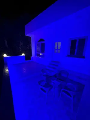 a blue room with chairs and tables in the dark at BePy's NUBIAN HOUSE in Aswan