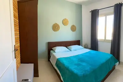 a bedroom with a bed with blue sheets and a window at Relaxing time in Makadi Heights in Hurghada