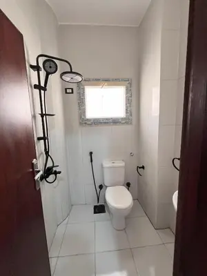 a bathroom with a toilet and a window at Downtown Keys in Hurghada