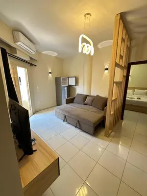 a living room with a bed and a television at Downtown Keys in Hurghada
