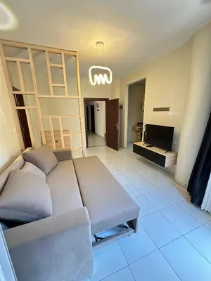 a living room with a couch and a television at Downtown Keys in Hurghada