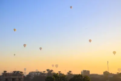 a group of hot air balloons in the sky at sunset at Moka Gust House in Luxor