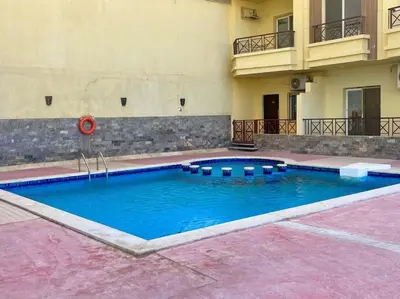 a swimming pool in front of a building at Beach Side 1 Bedroom Apartment in Hurghada