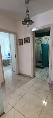 a living room with a ceiling fan and an open door at Cozy 1 bedroom Seaview escape in Hurghada