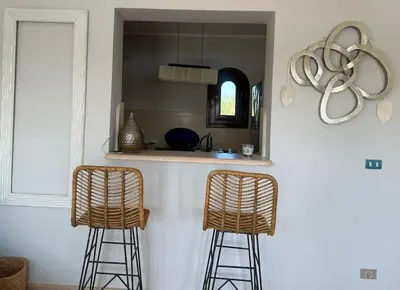 a kitchen with two bar stools and a sink at The Charming Beachfront Retreat in Fanadir in Hurghada