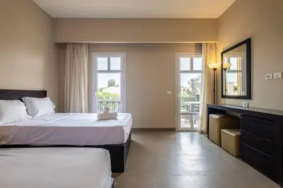 a hotel room with two beds and a mirror at Ocean View: Spacious 2-Bed Apt in Hurghada