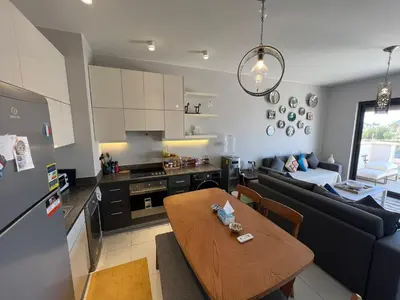 a kitchen and living room with a table and a couch at Chic Cyan 3BR Apt. • Prime Location in Hurghada