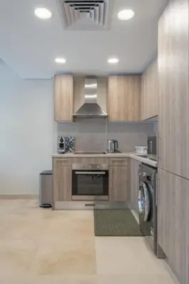 a kitchen with a stove and a washer and sink at Newly Furnished & Bright 2BR Apt: Mangroovy in Hurghada