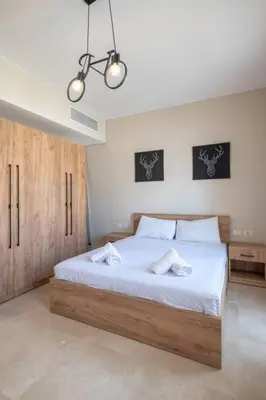 a bedroom with a large bed with two towels on it at Newly Furnished & Bright 2BR Apt: Mangroovy in Hurghada