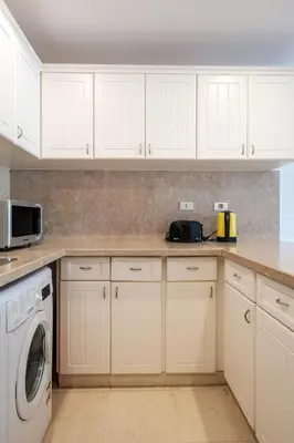 a kitchen with white cabinets and a washer and dryer at 2BR New Marina Retreat • Private Pool in Hurghada