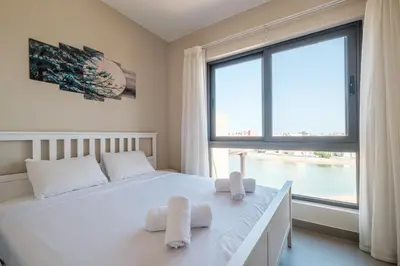 a bedroom with a bed and a large window at Chic Tawila 1BR • Pristine & Modern in Hurghada