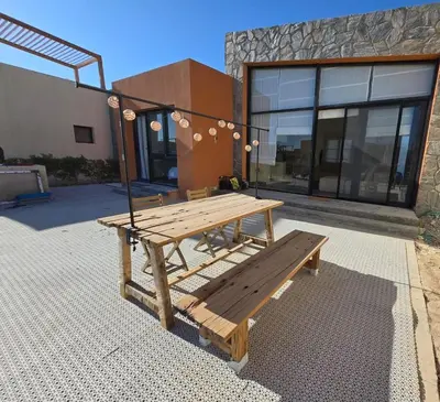 a wooden picnic table in front of a building at Somabay Beach House BW in Hurghada