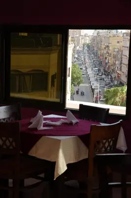 a table in a restaurant with a view of a street at Grand Memphis Hotel in Luxor in Luxor