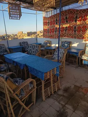 a restaurant with blue tables and chairs with a view at Grand Square Hostel Luxor in Luxor