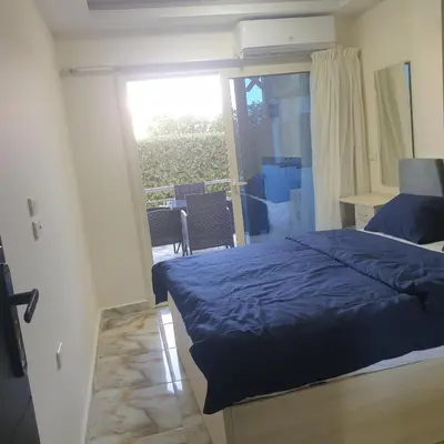 a bedroom with a blue bed and a balcony at Cecelia Beach Resort - 2 Rooms with terace in Hurghada