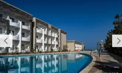 a swimming pool in front of a building at Cecelia Beach Resort - 2 Rooms with terace in Hurghada