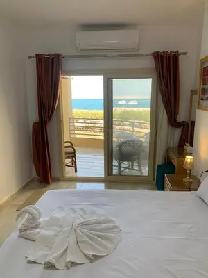a bedroom with a bed with a view of the ocean at Quiet quarter and private beach in Hurghada