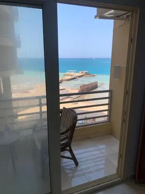 a chair on a balcony with a view of the beach at Quiet quarter and private beach in Hurghada