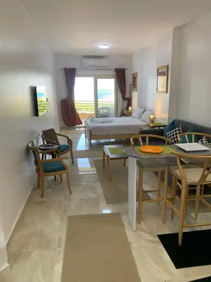 a living room with a bed and a table and chairs at Quiet quarter and private beach in Hurghada