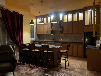 a kitchen with a island with bar stools at Amenti House - Private Villa & Retreat Center in Luxor