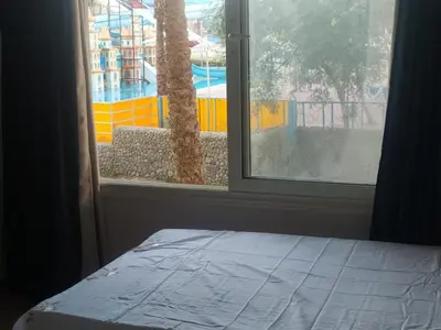 a bedroom with a window looking out at a pool at ميراج in Hurghada