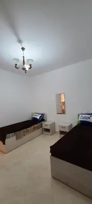 a bedroom with two beds and a ceiling fan at Hurghada Al Hilal District in Hurghada