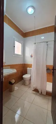 a bathroom with a toilet and a tub and a shower curtain at Hurghada Al Hilal District in Hurghada
