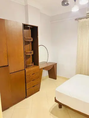 a bedroom with a bed and a dresser and a refrigerator at Sheraton St in Hurghada