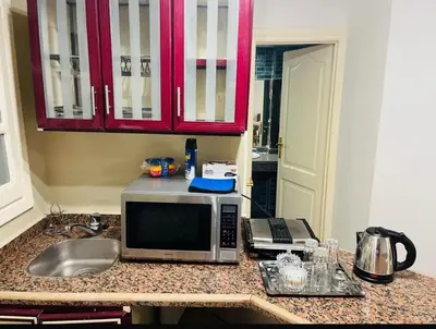 a kitchen counter with a microwave and a sink at Sheraton St in Hurghada
