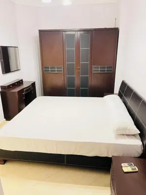 a bedroom with a large bed and a wooden cabinet at Sheraton St in Hurghada