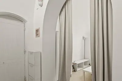 a white room with a mirror and a curtain at The Downtown Getaway Studio in Hurghada