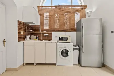a kitchen with a refrigerator and a washing machine at The Downtown Getaway Studio in Hurghada