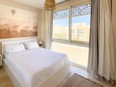 a bedroom with a white bed and a large window at El Gouna at Birdnest in Hurghada