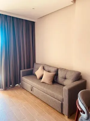 a couch in a living room with blue curtains at Luxury Chalet in Alsaraya, Overlooking All of Sahl Hasheesh with Stunning Pool & Red Sea Views in Hurghada