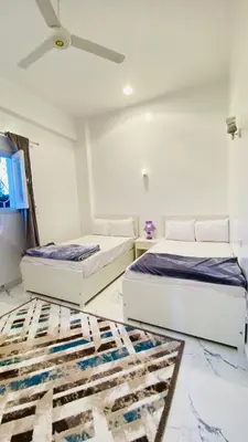 two beds in a room with a ceiling fan at Star - private apartments in Luxor