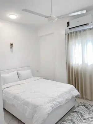 a white bedroom with a white bed and a window at Star - private apartments in Luxor