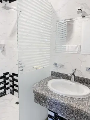 a white bathroom with a sink and a shower at Star - private apartments in Luxor