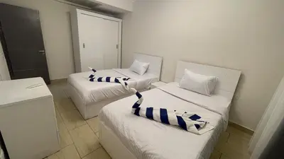 two beds with striped pillows in a room at Dani Apartment at Aldau Heights in Hurghada