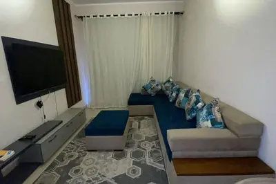a living room with a couch and a flat screen tv at Family apartment Aldau Heights in Hurghada