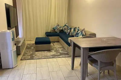 a living room with a blue couch and a table at Family apartment Aldau Heights in Hurghada