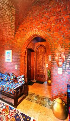 a brick room with a bed and a face on the wall at Luxor Tower in Luxor