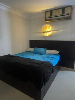 a bedroom with a bed with blue sheets and a light at The view in Hurghada