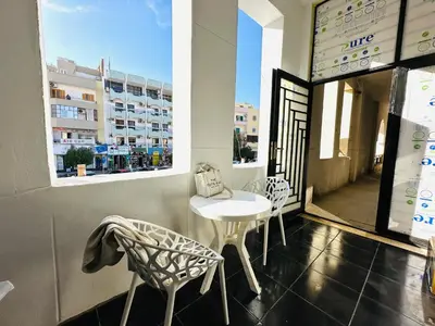 a small white table and chairs on a balcony at Falcon Loft Studio Sheraton Road in Hurghada