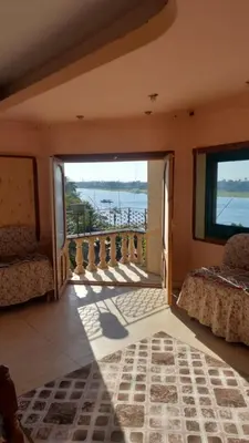 a room with a balcony with a view of the water at The Best View With Great Location 2 Bedroom Apartment in Luxor in Luxor