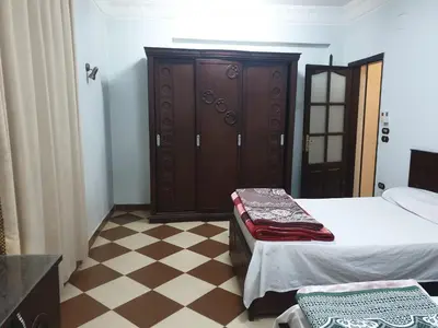 a bedroom with a bed and a wooden cabinet at El Quarn Apartment in ‘Ezbet Abu Ḥabashi
