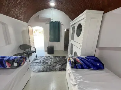 a room with two beds in a room with a door at Mido Tag in Aswan