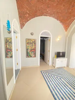 a living room with a rug and paintings on the walls at HF - residency in Luxor