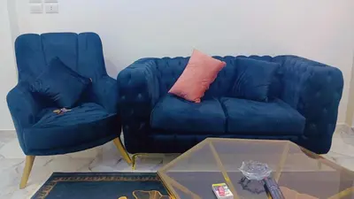a blue couch and two chairs in a living room at اهلا بيكم في بيتنا in Jazīrat al ‘Awwāmīyah