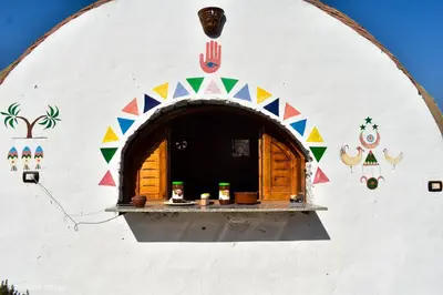 a white building with a window with colorful decorations on it at ASSINGAR camp in Jazīrat Suhayl