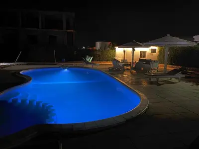 a large blue swimming pool at night at Hurghada-Magawish Studio 1 in Hurghada